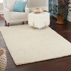 a living room with a white rug and chair