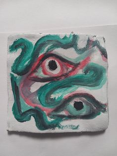 a piece of art that looks like a face with green and red paint on it