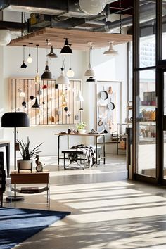 an office with lots of hanging lights and furniture