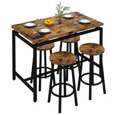 a wooden table with four stools and plates on the top, in front of a white background