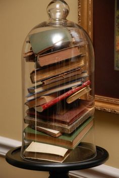 there is a glass dome with books under it