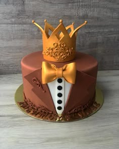 a cake decorated with a tuxedo, bow tie and a crown on top