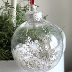 a glass ornament with snowflakes hanging from it