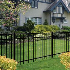 a black fence in front of a large house