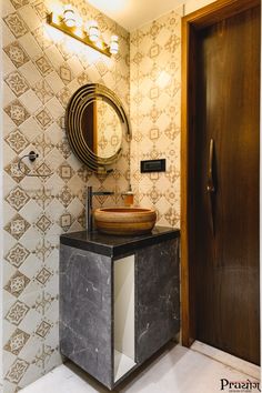 a bathroom with a sink, mirror and tiled wallpaper in the shower stall area