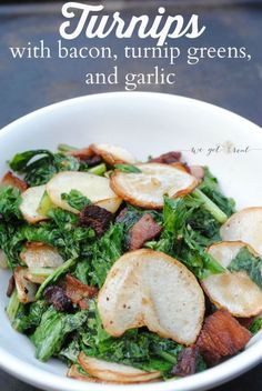 a white bowl filled with potatoes and greens on top of a black tablecloth next to a