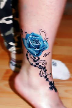 a woman's foot with a black rose tattoo on the side of her leg