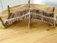 a piece of wood that is sitting on top of a wooden table with sticks attached to it