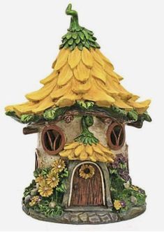 a small house with bananas on the roof and flowers growing around it's windows