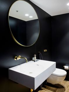 a black and white bathroom with gold accents