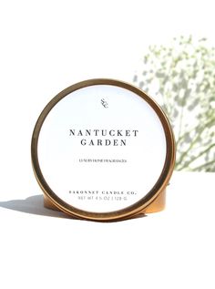 nantucket garden handmade candle tin in front of a white background with flowers