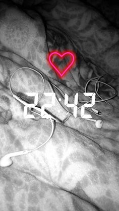 a bed with headphones and a red heart on it