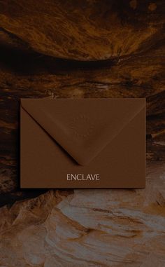 an envelope with the word enclave written on it in front of a marble background