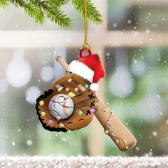 a baseball glove ornament hanging from a christmas tree branch with lights on it