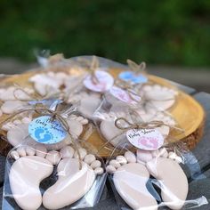 baby feet cookies wrapped in cellophane and tied with twine on a platter