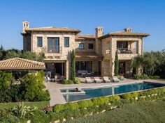 a large house with a swimming pool in the front yard and patio area next to it