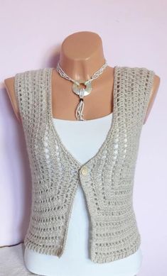 a white mannequin wearing a gray sweater vest and a necklace on it's neck