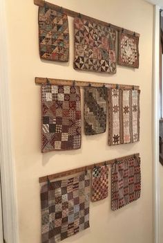 several pieces of quilt hanging on a wall