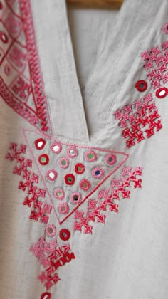 an embroidered white shirt with pink and red details