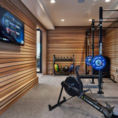 a home gym with an exercise bike, rowing machine and other equipment in the room