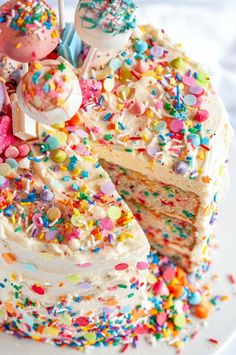 a birthday cake with sprinkles and candies on the top is ready to be eaten