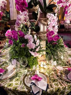 the table is set with pink flowers and place settings