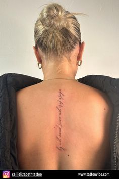 the back of a woman's neck with words written on her upper and lower back