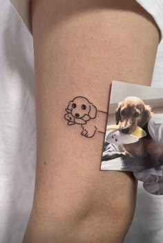 a dog with a bone in its mouth on the side of a woman's thigh