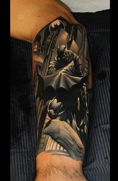 a man's arm with batman tattoos on it