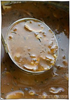 a ladle full of soup is sitting on top of the pot filled with liquid