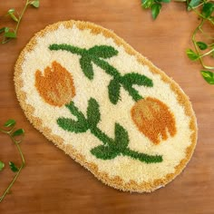 a piece of bread with flowers on it sitting on a table next to green leaves