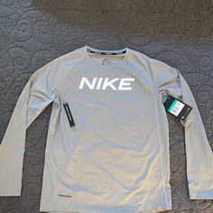 Nike Pro Dry For Long Sleeve Grey Boys Xl Shirt Sports Long Sleeve Shirt With Letter Print, Long Sleeve Sports Shirt With Letter Print, Casual Long Sleeve Moisture-wicking Shirt, Nike Tops In Athletic Heather With Logo Print, Nike Athletic Heather Moisture-wicking Tops, Nike Moisture-wicking Athletic Heather Tops, Nike Long Sleeve Cotton Shirt, Nike Cotton Long Sleeve Shirt, Gray Long Sleeve Sports Tops