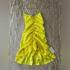 a yellow dress is hanging on a clothes hanger and it's not too bright