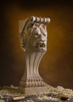 a sculpture of a lion's head is surrounded by wood shavings