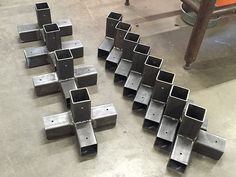 many square and rectangular steel pieces are arranged on the floor