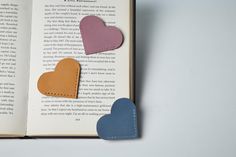 an open book with hearts cut out of it