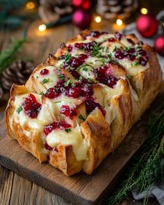 bread with cranberry sauce and cheese on a cutting board next to christmas decorations