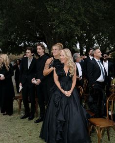 two women in black dresses standing next to each other