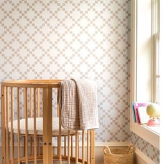 a baby's crib in the corner of a room next to a window