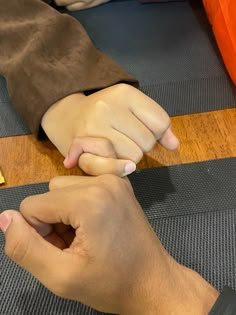 two hands holding each other on top of a table