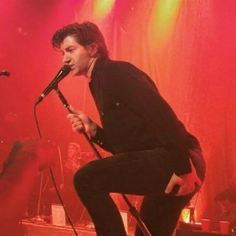 a man standing on top of a stage holding a microphone