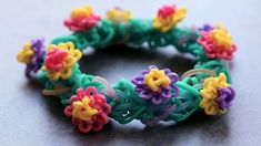 a close up of a bracelet made out of plastic beads with flowers on the side