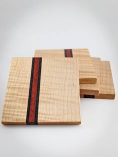 three wooden coasters with red and black stripes