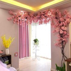 a room with pink curtains and flowers on the wall