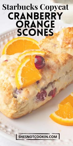 an orange and cranberry scones on a plate next to some sliced oranges