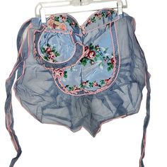 an item is hanging on a metal rack with blue fabric and pink flowers in it