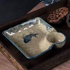 a blue and white dish sitting on top of a wooden tray next to some cookies