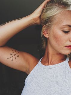 a woman with tattoos on her arm and shoulder is looking down at the viewer's phone