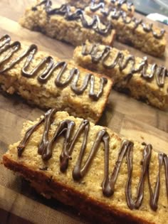 several pieces of bread with chocolate drizzled on them sitting on a cutting board