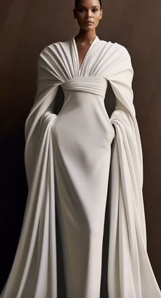 a woman in a white gown and cape